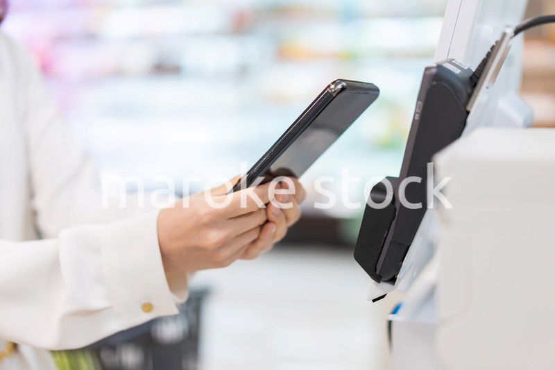 セルフレジ・電子マネー決済をする若い女性