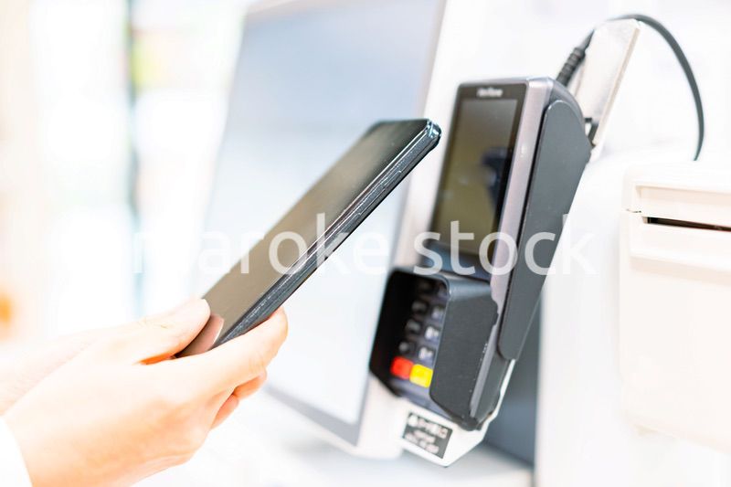 スマホ決済で支払う若い女性