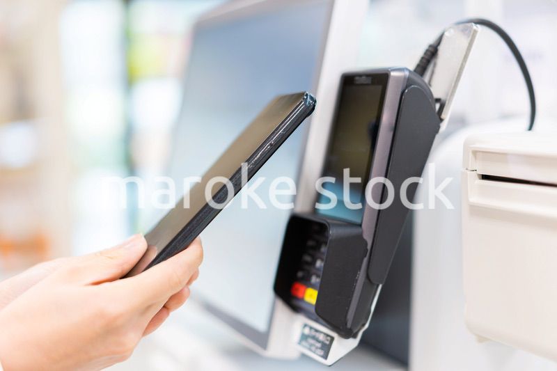 セルフレジ・電子マネー決済をする若い女性
