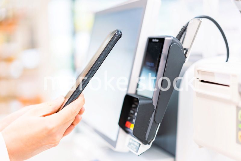 スマホ決済で支払う若い女性