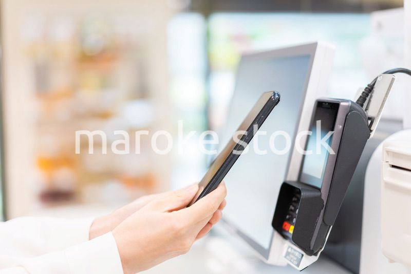 セルフレジ・電子マネー決済をする若い女性