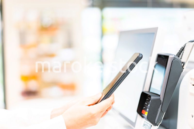 スマホ決済で支払う若い女性