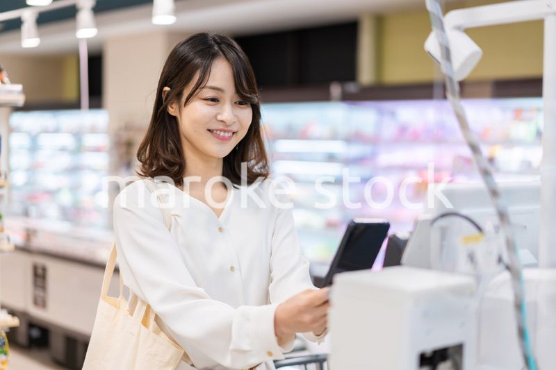 セルフレジ・電子マネー決済をする若い女性
