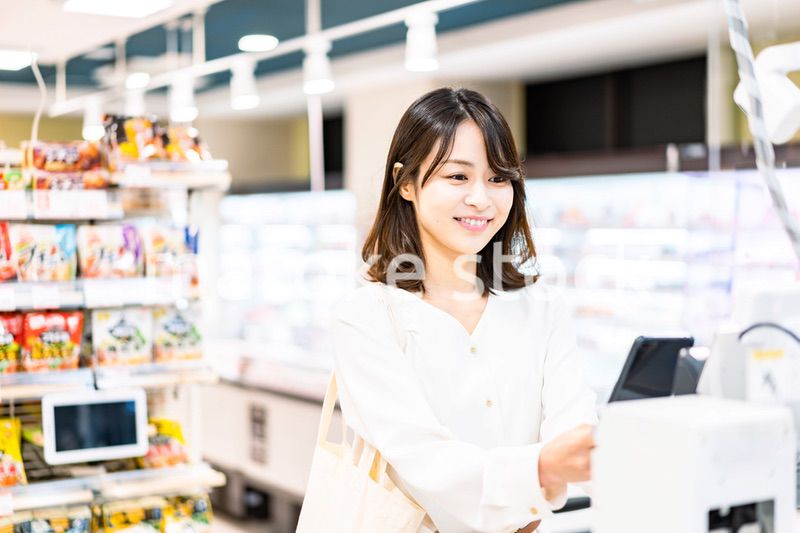 スマホ決済で支払う若い女性