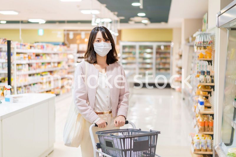 マスクをしてスーパーで買い物をする主婦