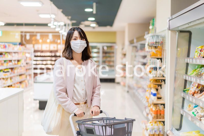 マスクをしてスーパーで買い物をする主婦