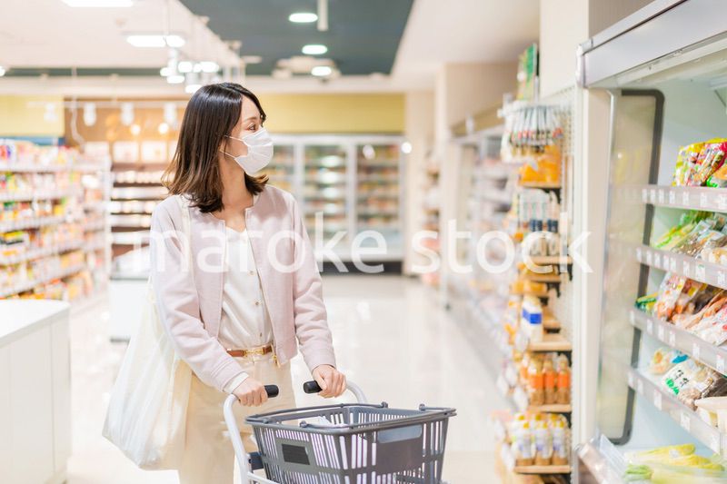 マスクをしてスーパーで買い物をする主婦