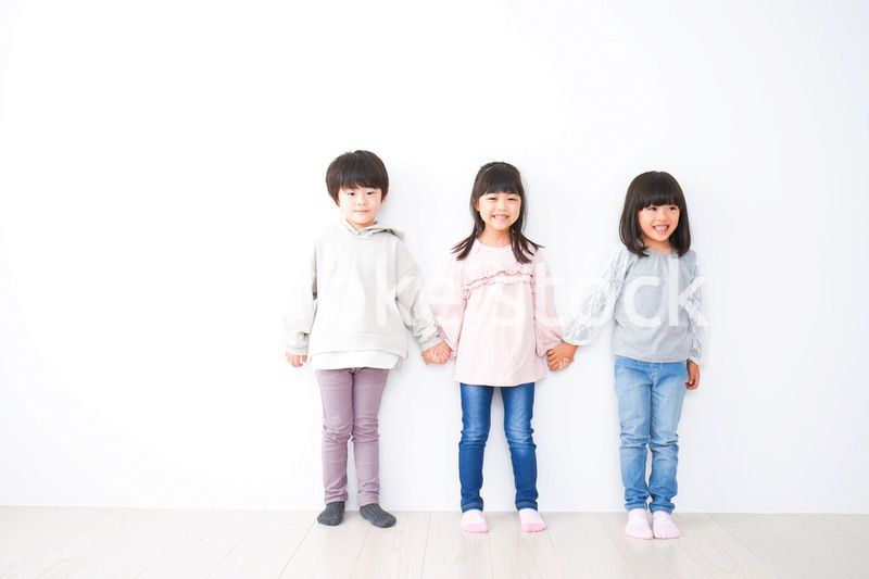 壁に並ぶ3人の子どもたち