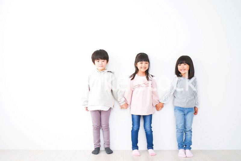 壁に並ぶ3人の子どもたち