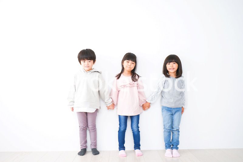 壁に並ぶ3人の子どもたち