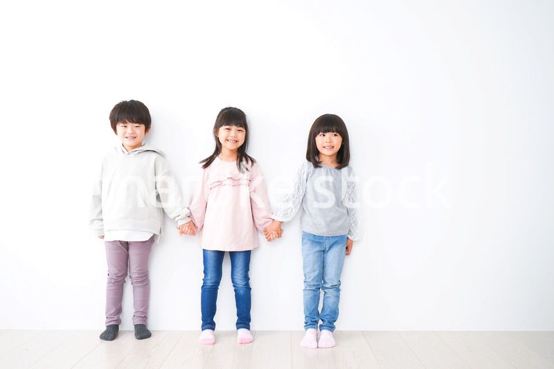 壁に並ぶ3人の子どもたち