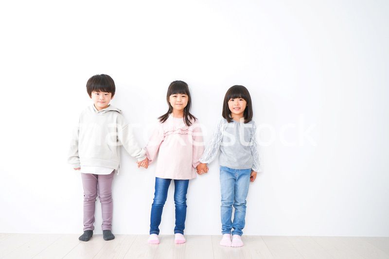 壁に並ぶ3人の子どもたち