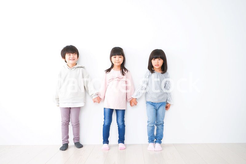 壁に並ぶ3人の子どもたち