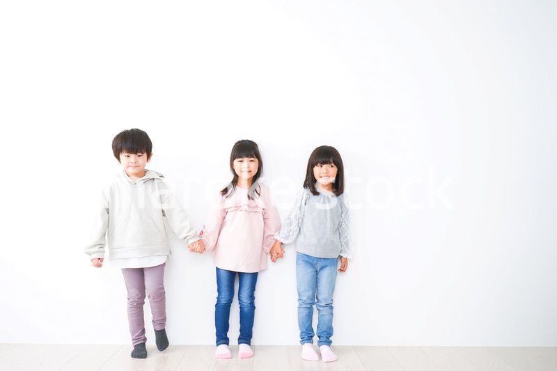 壁に並ぶ3人の子どもたち