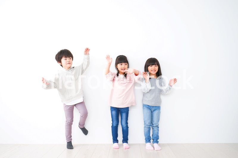 壁に並ぶ3人の子どもたち
