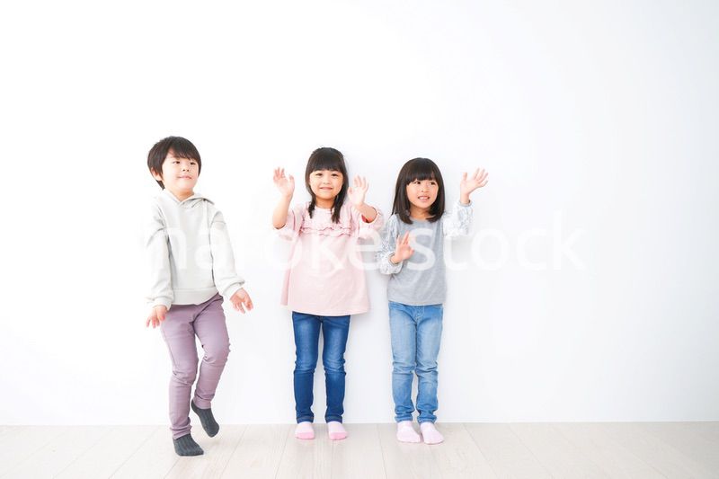 壁に並ぶ3人の子どもたち