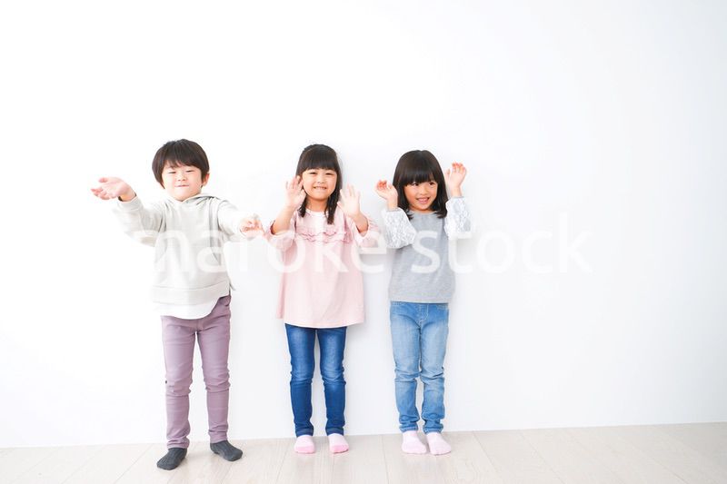 壁に並ぶ3人の子どもたち