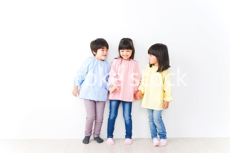 壁に並ぶ3人の幼稚園児
