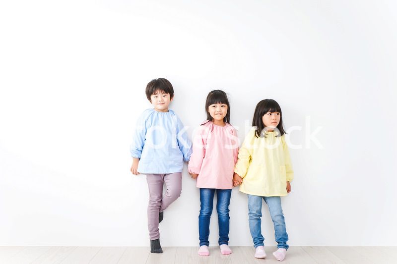 壁に並ぶ3人の幼稚園児