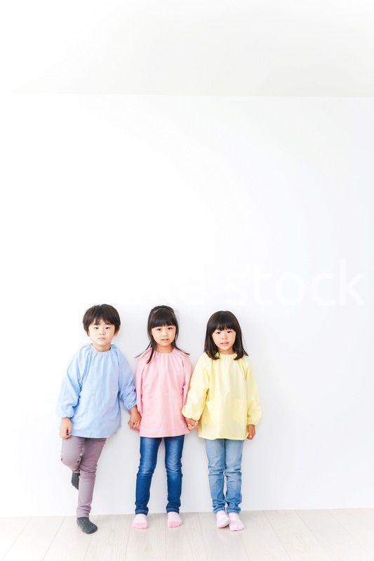 壁に並ぶ3人の幼稚園児
