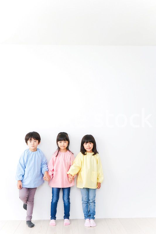 壁に並ぶ3人の幼稚園児