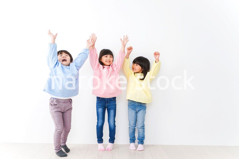 壁に並ぶ3人の幼稚園児