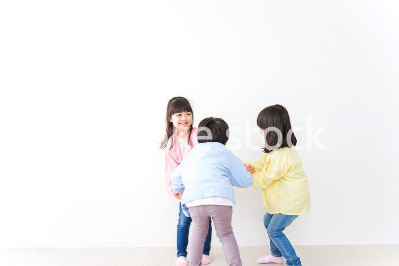 壁に並ぶ3人の幼稚園児