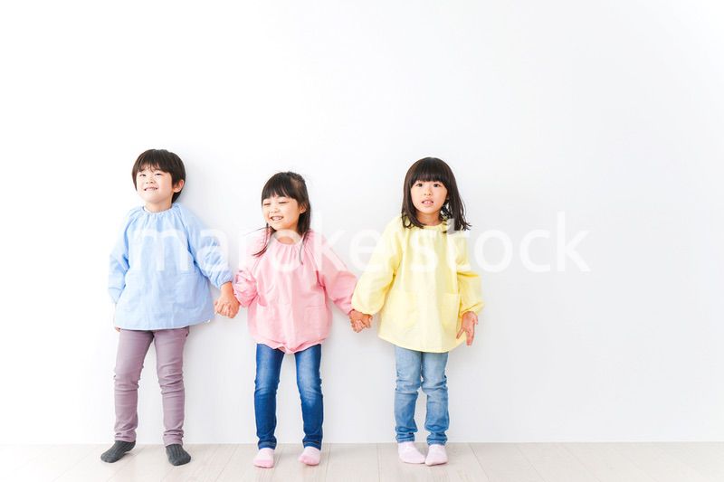壁に並ぶ3人の幼稚園児