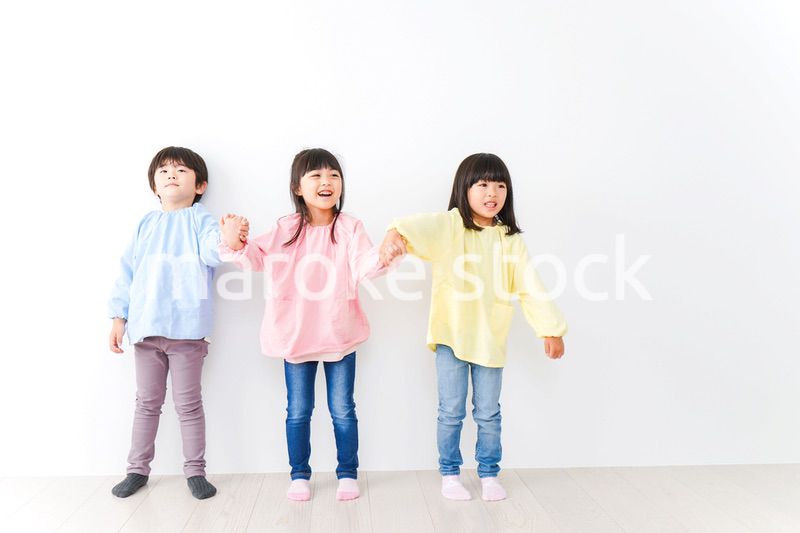 壁に並ぶ3人の幼稚園児