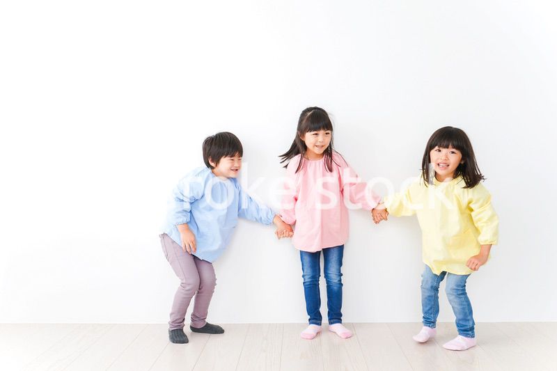 壁に並ぶ3人の幼稚園児