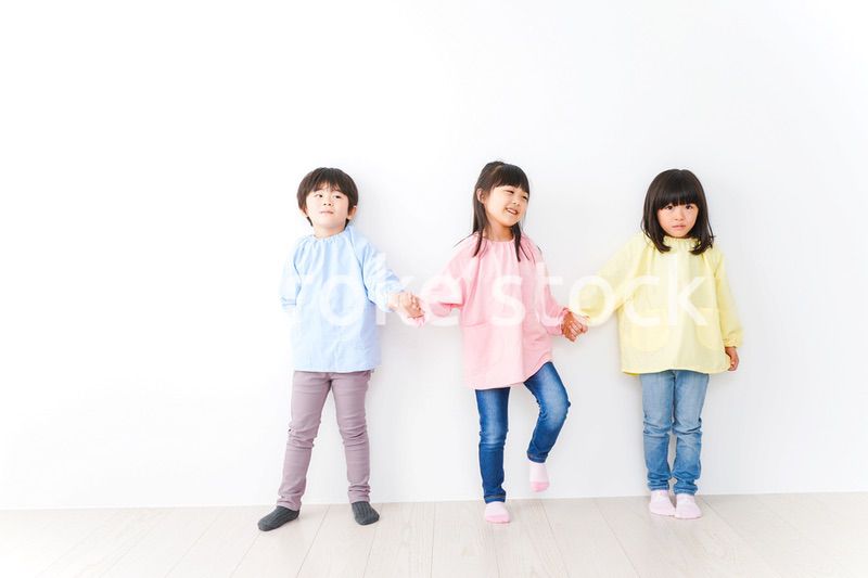 壁に並ぶ3人の幼稚園児