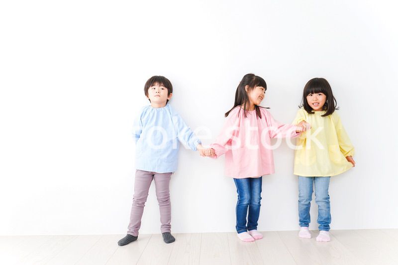 壁に並ぶ3人の幼稚園児