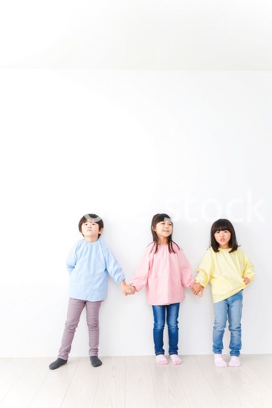 壁に並ぶ3人の幼稚園児