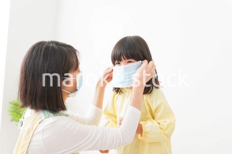 子供にマスクをつける保育士