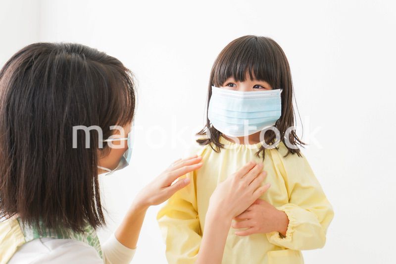子供にマスクをつける保育士