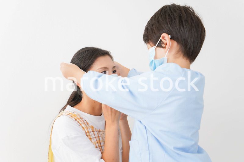 お母さんにマスクをつける子供