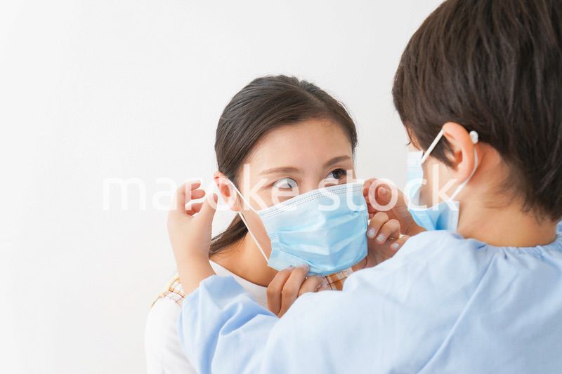 お母さんにマスクをつける子供