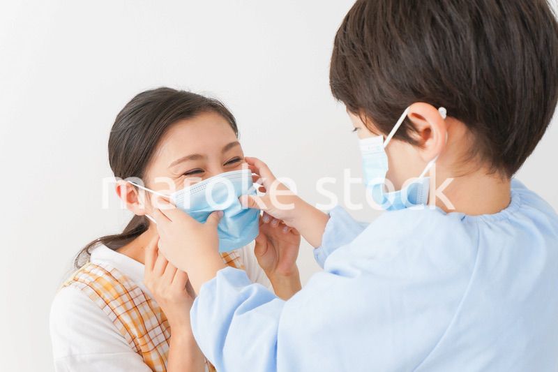 お母さんにマスクをつける子供