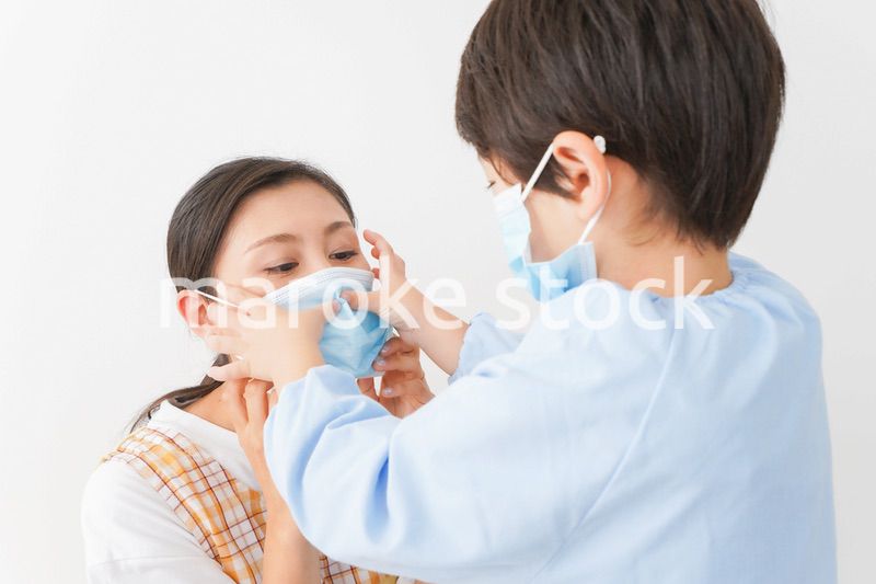 お母さんにマスクをつける子供