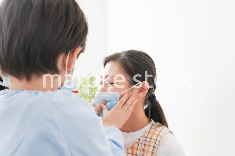 お母さんにマスクをつける子供