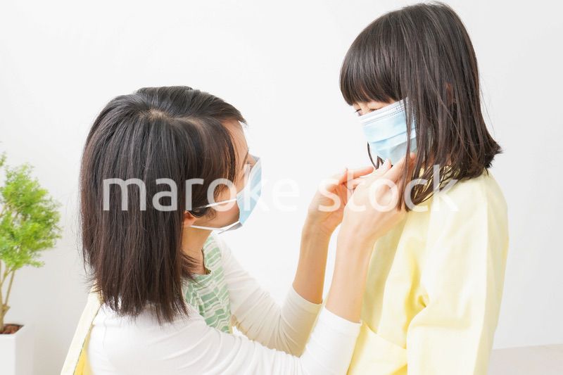 子供にマスクをつける保育士