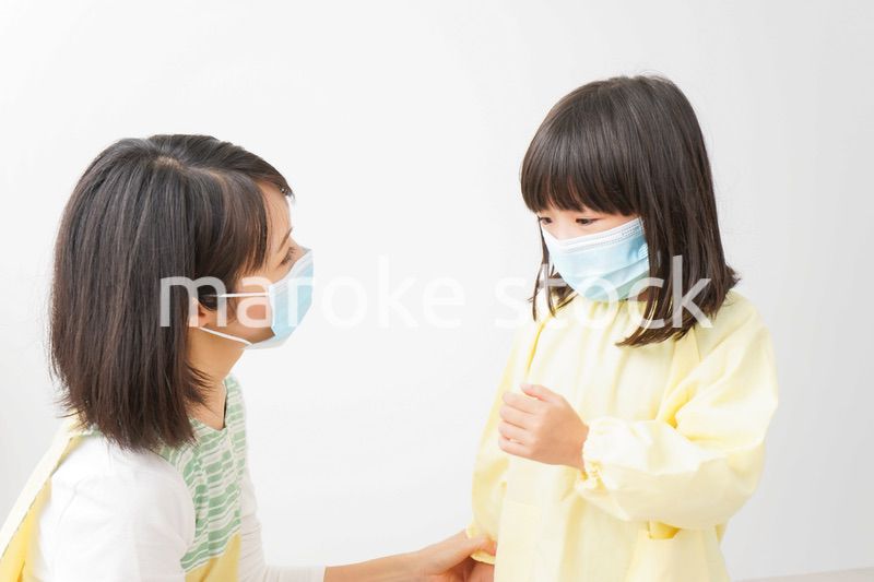 子供にマスクをつける保育士