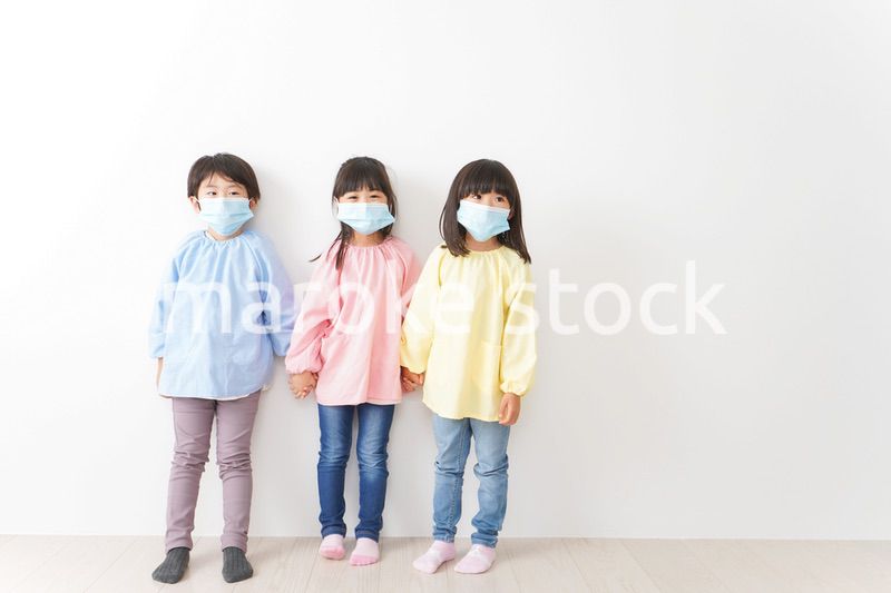マスクをつけて手を繋ぐ幼稚園児
