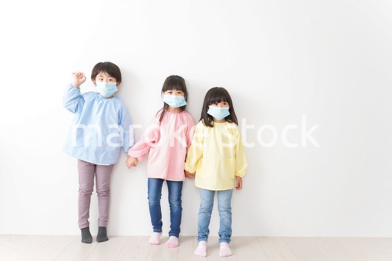 マスクをつけて手を繋ぐ幼稚園児