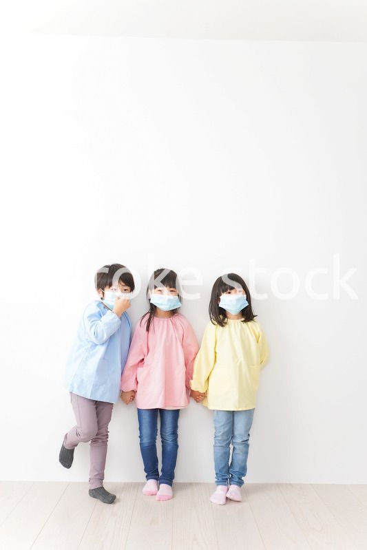 マスクをつけて手を繋ぐ幼稚園児
