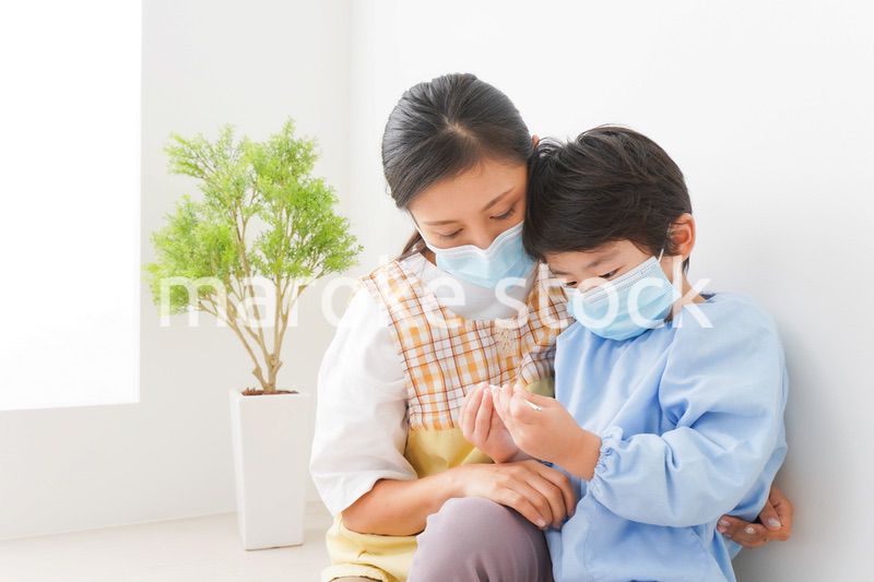 体温を測定する子供と幼稚園の先生