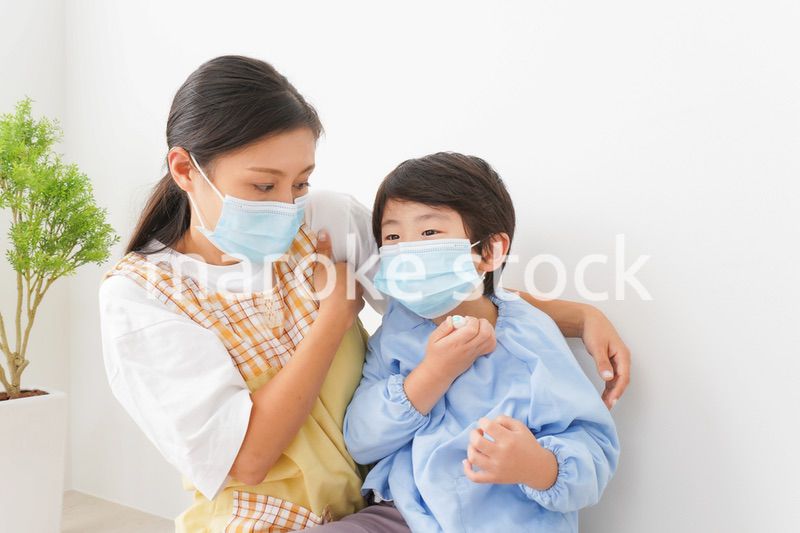 体温を測定する子供と幼稚園の先生