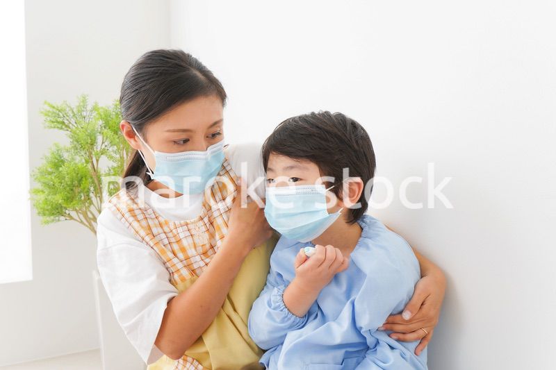 体温を測定する子供と幼稚園の先生