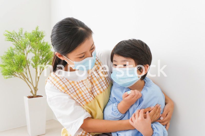 体温を測定する子供と幼稚園の先生