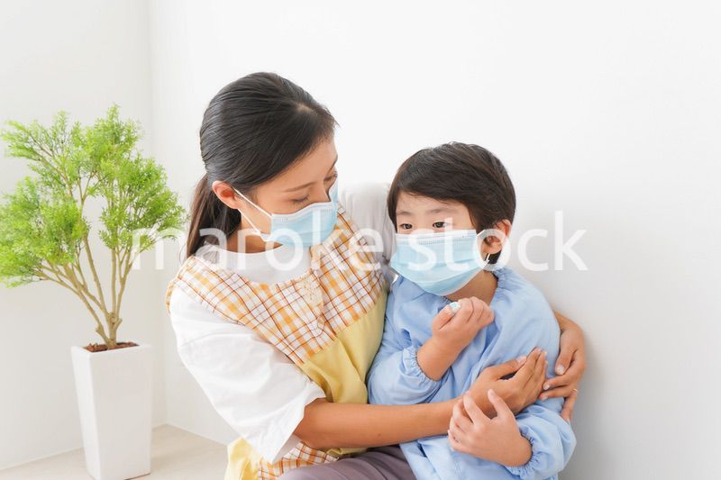 体温を測定する子供と幼稚園の先生